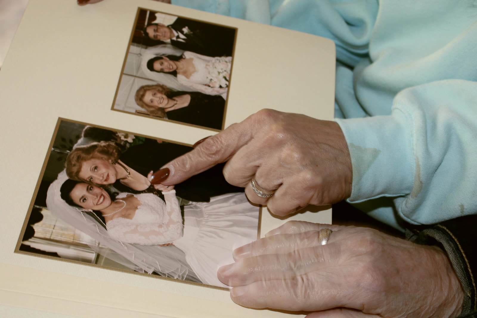 Eine ältere Frau hält ein Foto von sich als junges Mädchen in der Hand